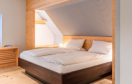 schickes Bett aus Holz nach Maß mit schöner Maserung und natürlichem Aussehen Look n Feel mit hellem Holz und schickem Muster auf der Tapete